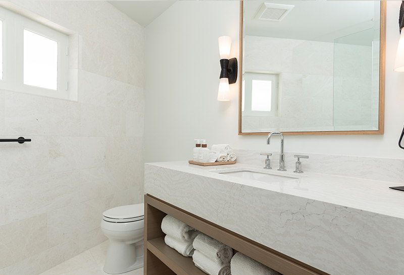 Elegant modern bathroom at Caerula Mar Club with marble countertop, open shelving, and soft lighting on South Andros Island, Bahamas.